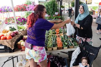 Women purchasing produce from a farmers market