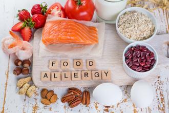 Major allergen foods on wooden table with ‘Food Allergy’ spelled out in tiles