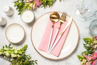spring decorated table setting with a pink napkin and fresh flowers