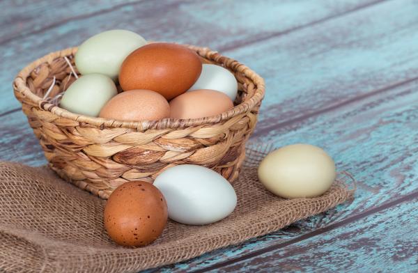 Multiple colored eggs in basket on table